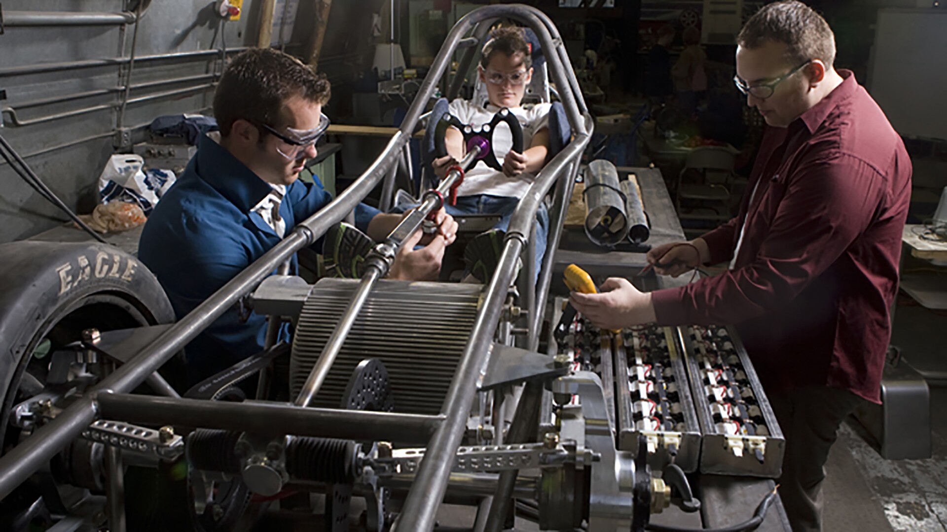 Several students working on a hybrid race car