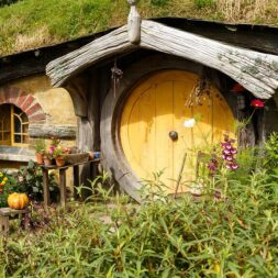 A small hobbit house with yellow door and garden.