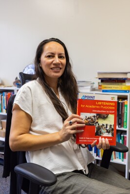 Professor Natasha Gillette holding a text book that she uses in majority of her classes