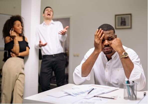 with with head in hand with another man laughing in the background