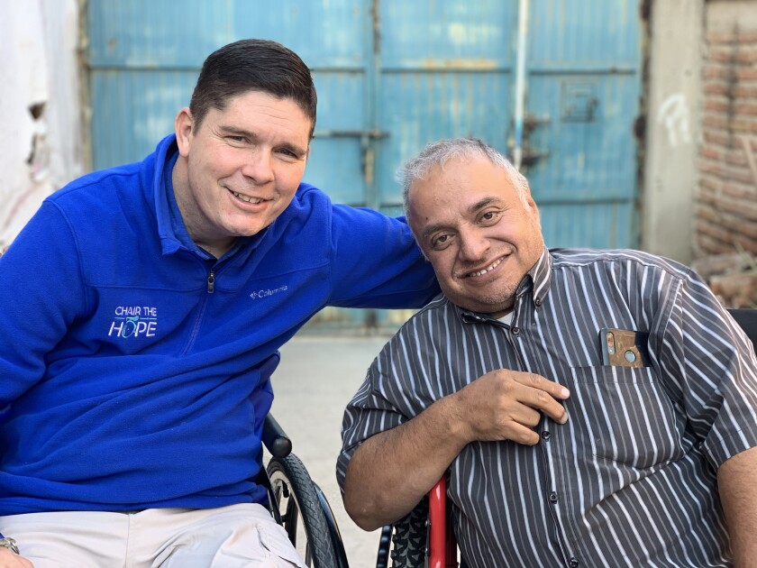 Two men in wheelchairs smiling