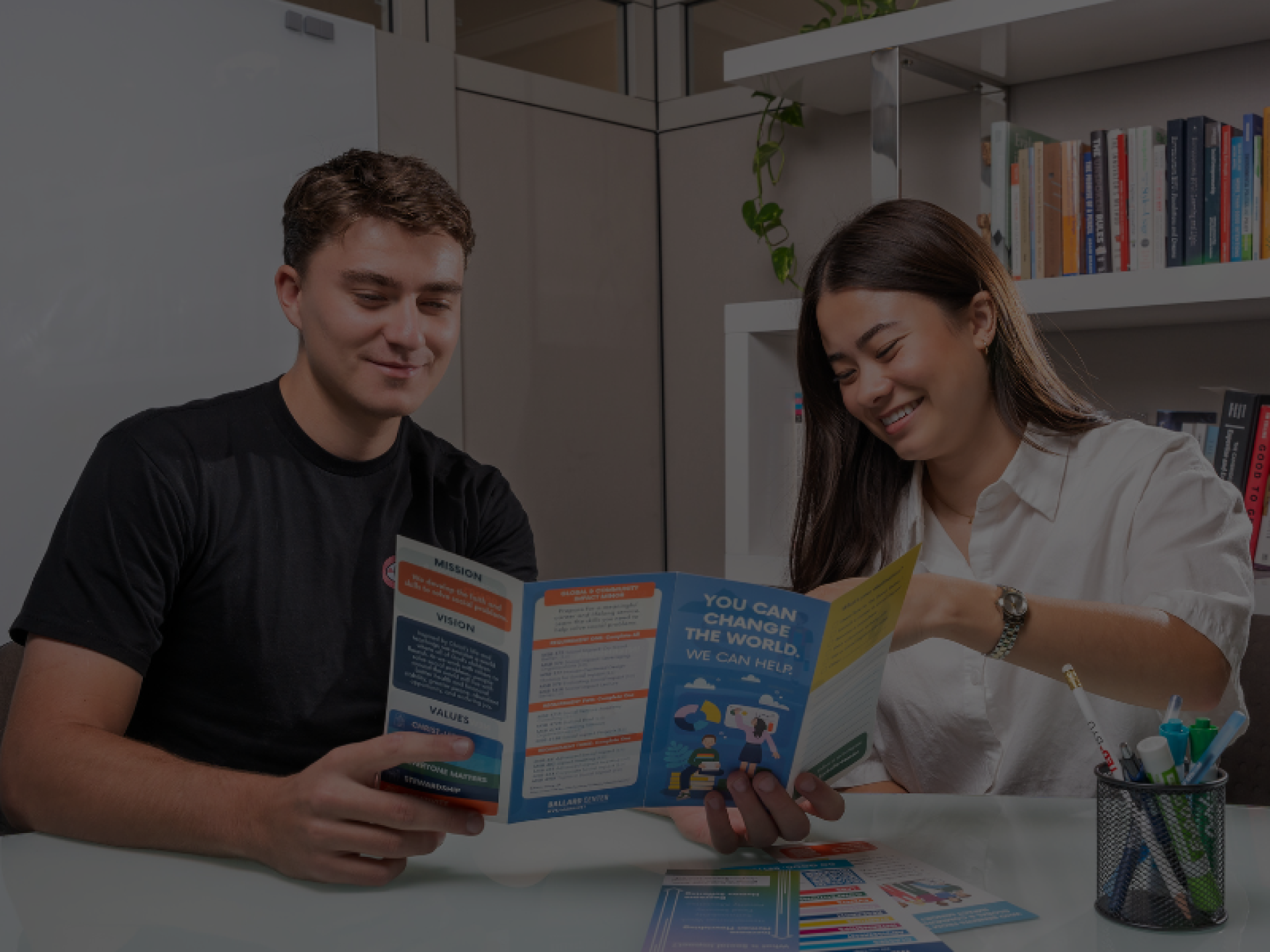 Advisement, Students at BYU Ballard Center reading a social impact advising brochure about programs, classes, and how to get involved