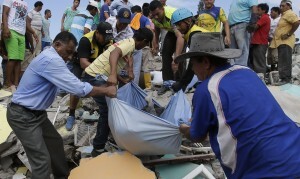 Volunteers rescue a body from a destroyed building after an earthquake in Pedernales, Ecuador, Sunday, April 17, 2016. The strongest earthquake to hit Ecuador in decades flattened buildings and buckled highways along its Pacific coast, sending the Andean nation into a state of emergency. (AP Photo/Dolores Ochoa)