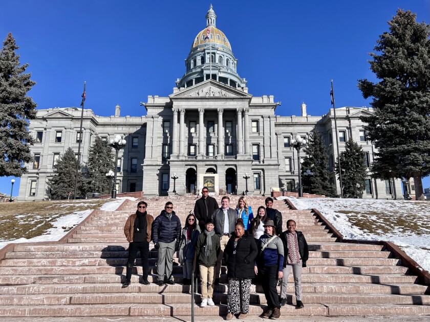 Students standing in front of the Denver capitol.