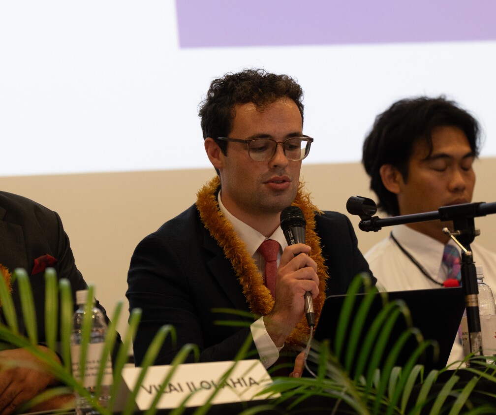 man with glasses speaking into microphone