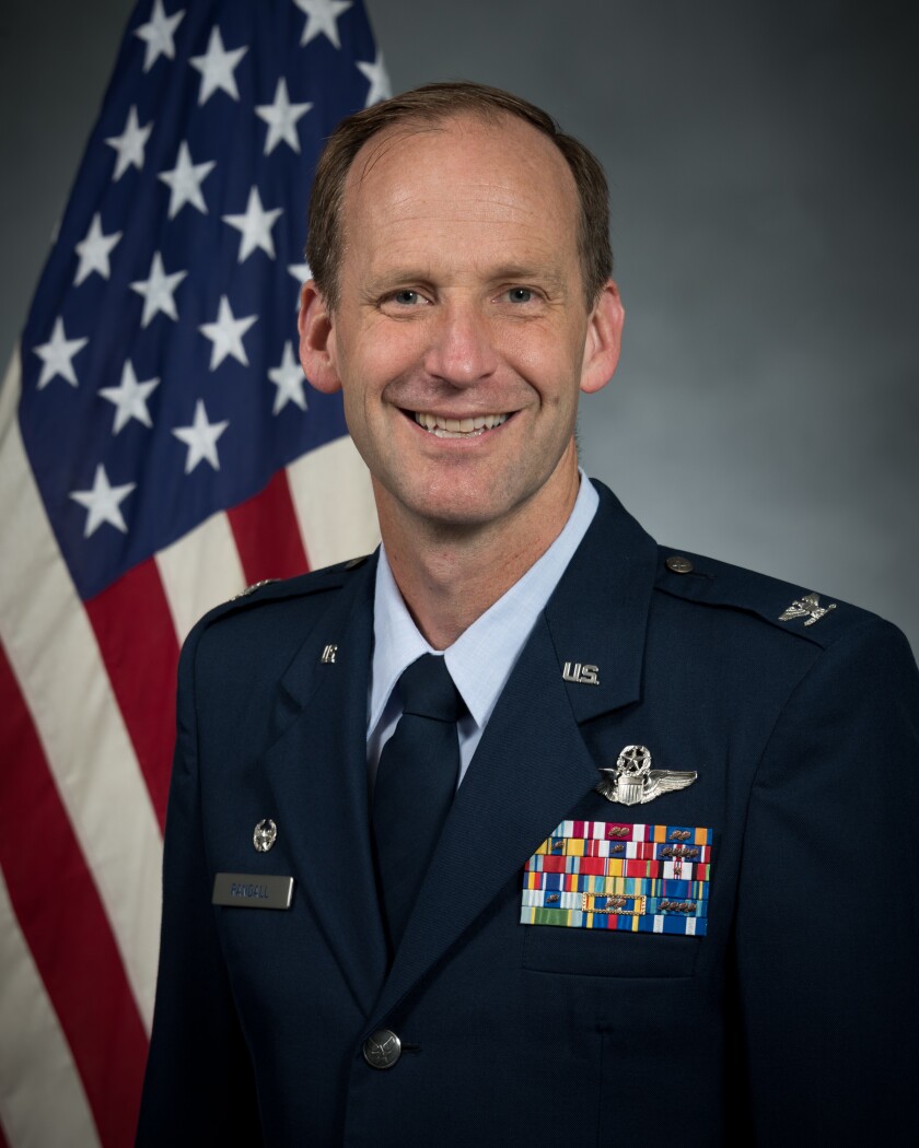 A headshot of Colonel Trigg E. Randall in his Air Force regalia, in front of an American flag.