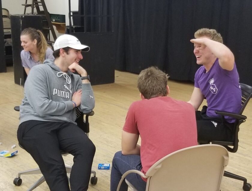 An image of three people sitting in a circle and talking