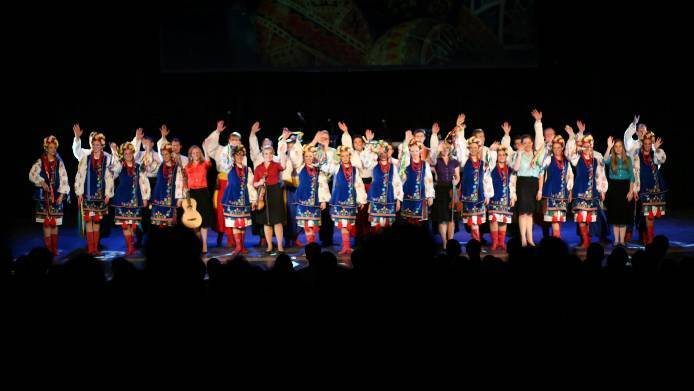 The International Folk Dance Ensemble waves to the audience during a standing ovation in O