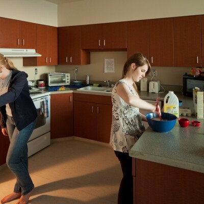 Kitchen at Heritage Halls featuring 2 students, fridge, microwave.