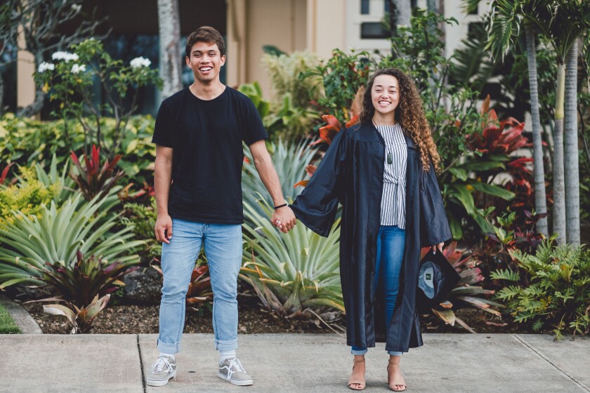 Nakitta Faupula Ellis and Ezrym Ellis hold hands in front of foliage in the Flag Circle.