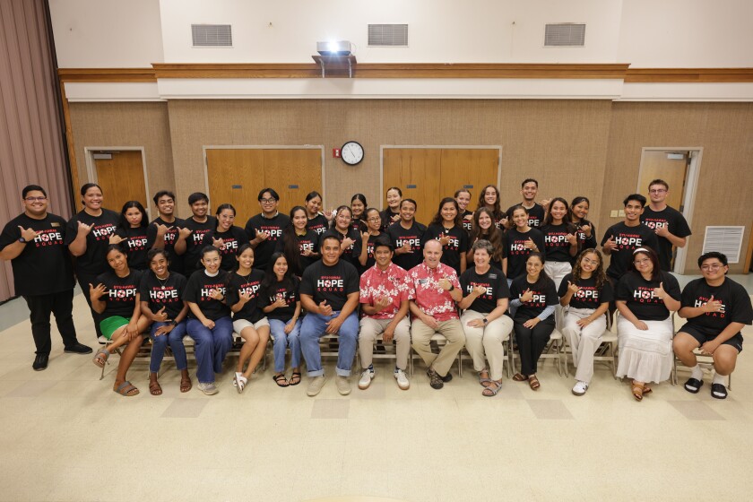 Hope Squad members posing for a photo with their Hope Squad shirt on.