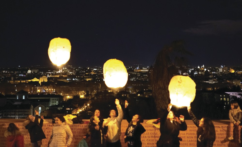A group of people letting go of three lanterns