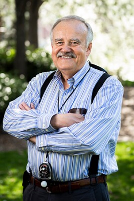 Rich Chesnut poses outside with his arms crossed, smiling