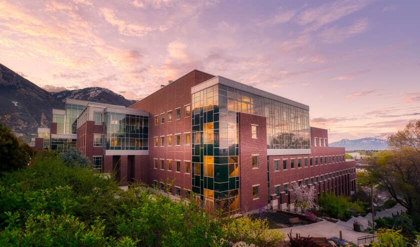 A photo of the new Life Sciences building at BYU, framed against a beautiful purple-pink sunset.