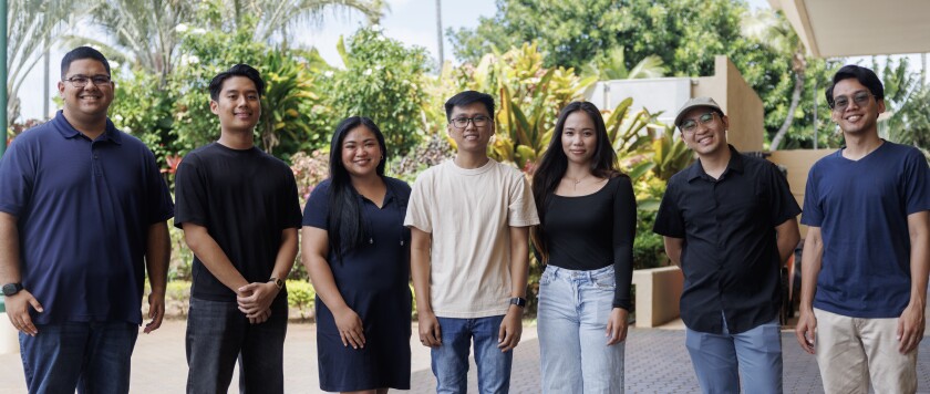 BYUH students standing shoulder to shoulder smiling.