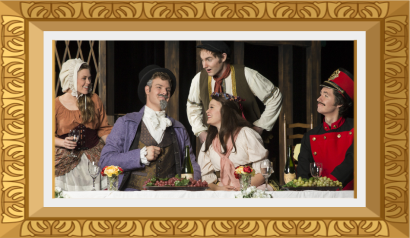 An image of some cast members dressed in costumes and eating a feast