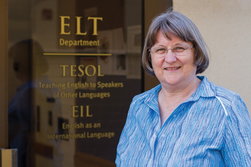 An older woman next to a door reading ELT Department