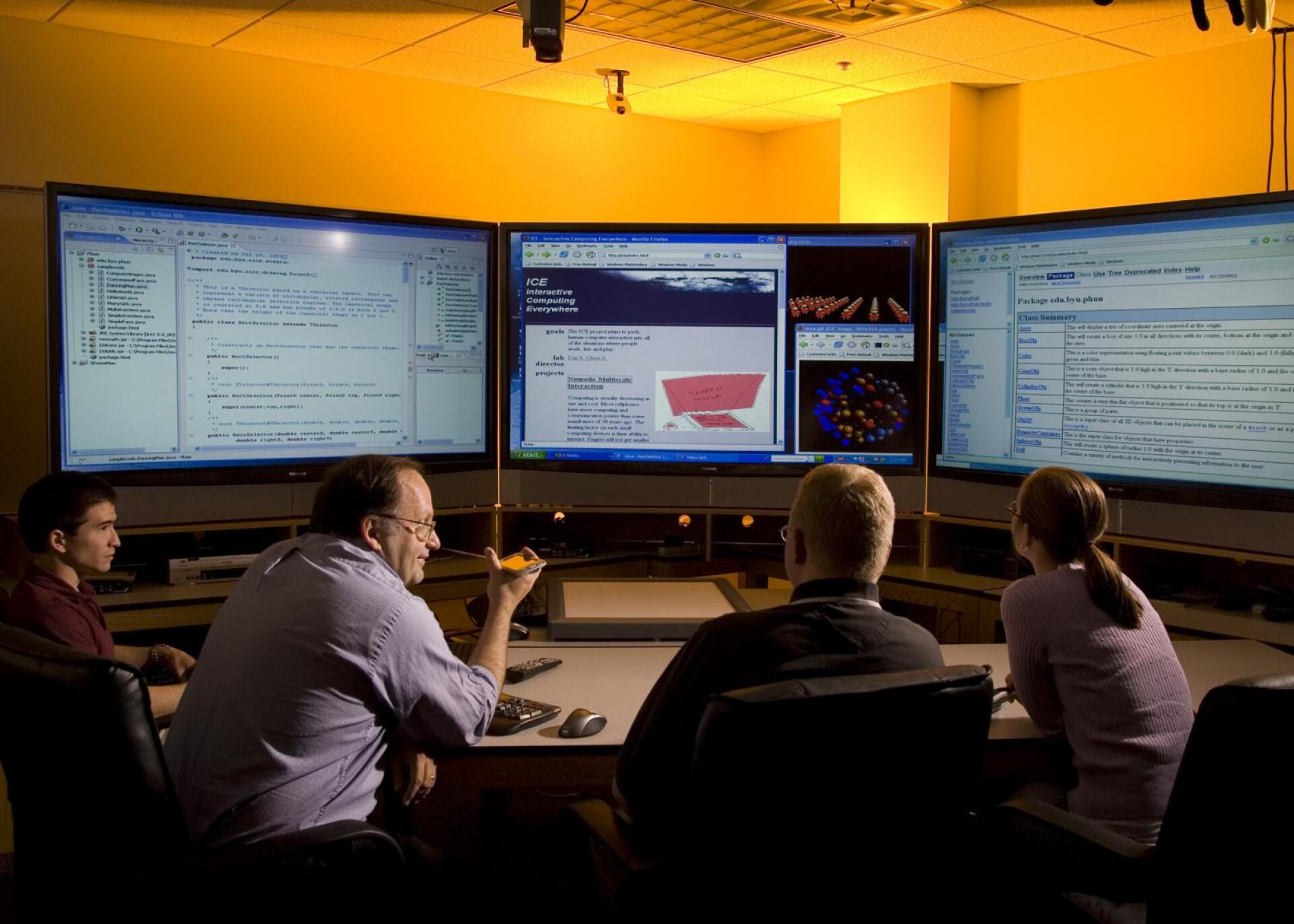 Students and Faculty looking at large monitors