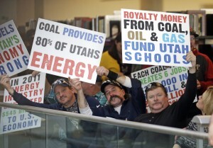 People display their signs during a public hearing to let federal regulators know what they think about a proposal to require more pollution controls at two of the state