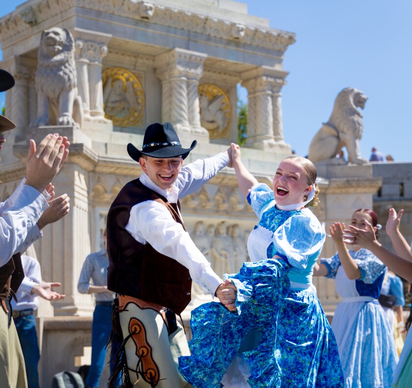 American Folk Dancers dance joyfully at a festival.