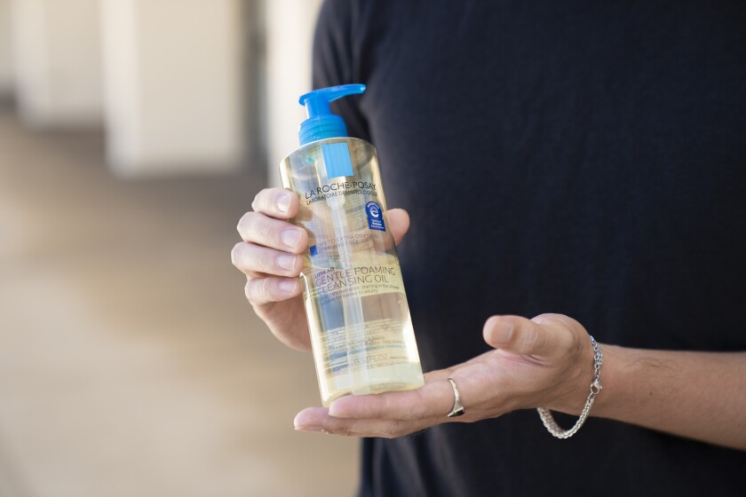 Dave Noynay holding La Roche Posay foaming cleansing oil.