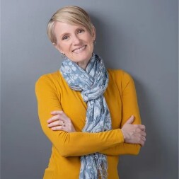 Joani Elliot standing with arms crossed.