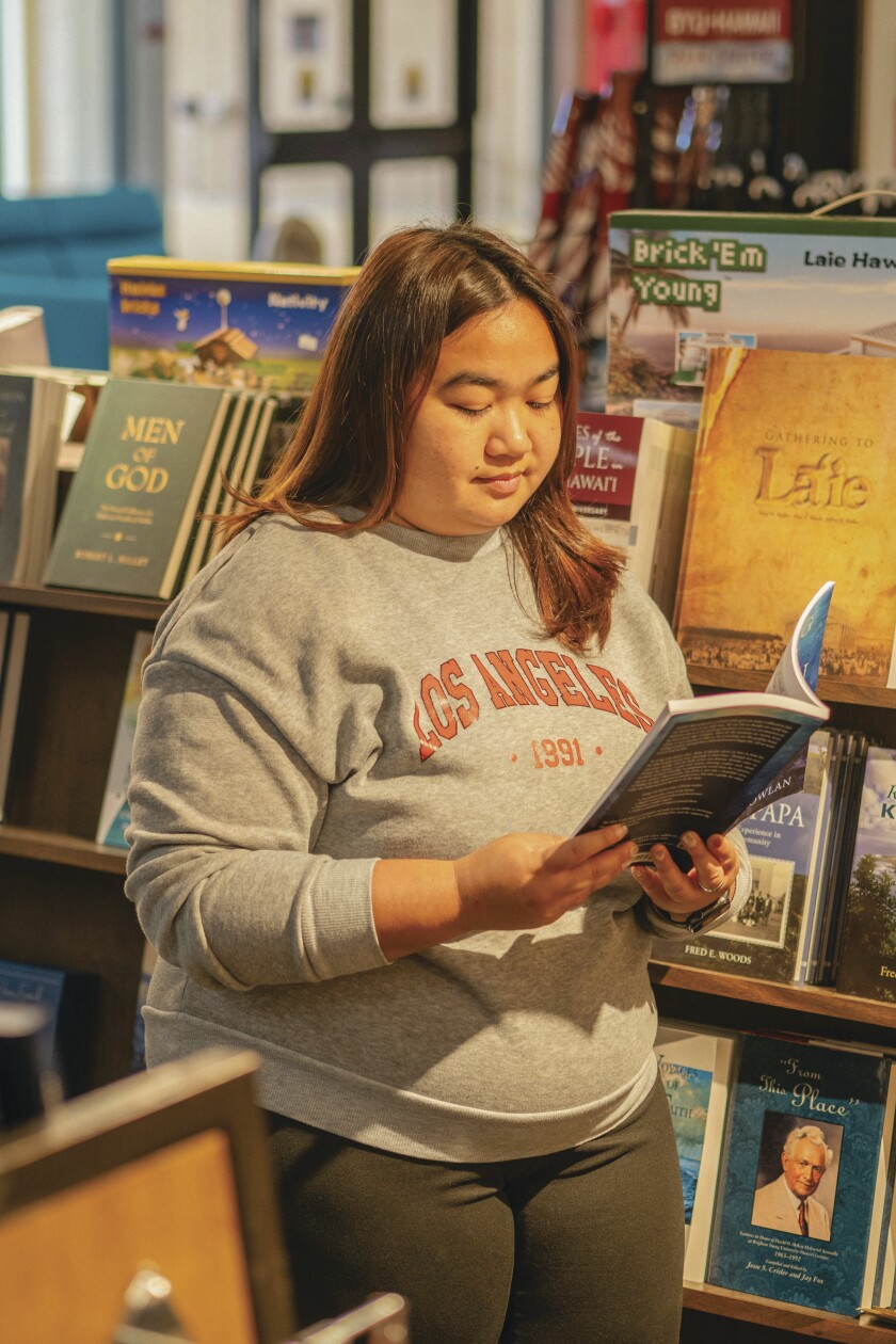 Kantima Romyasai reading a book in the BYUH store.