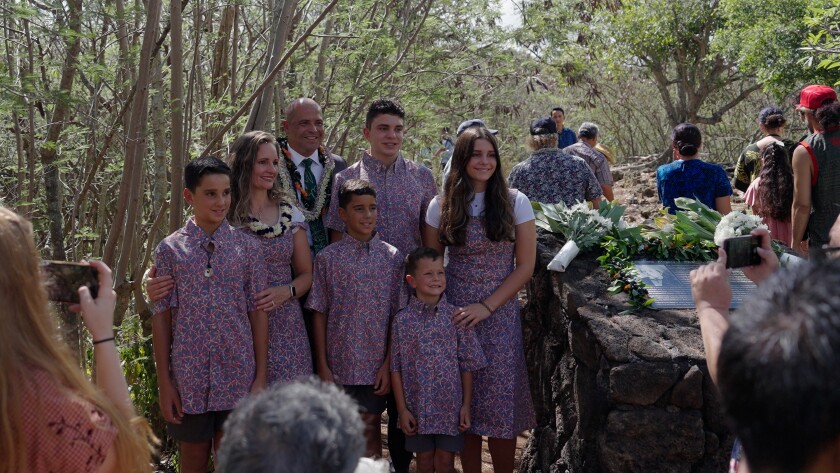 Kauwe family gathered by the memorial plaque.