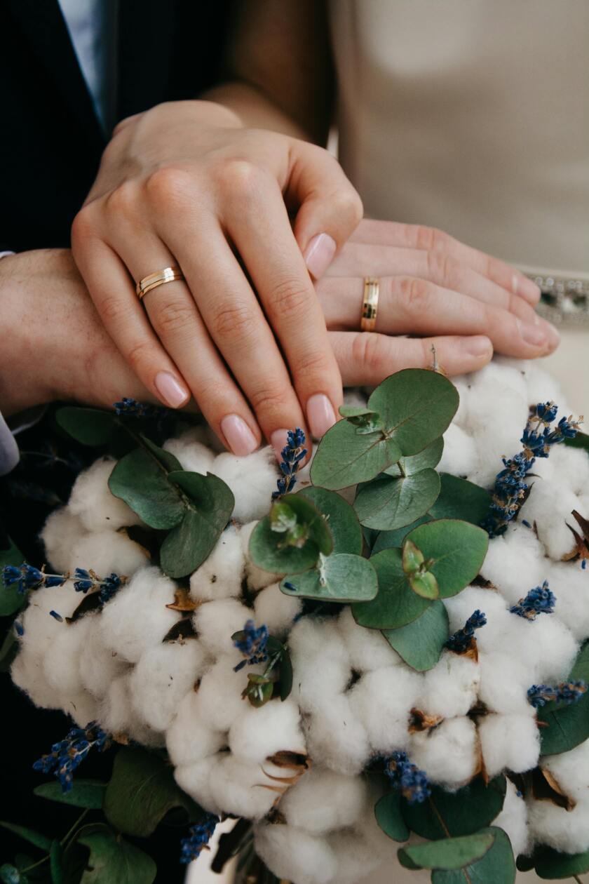 man and woman hand on a bouquet of flowers