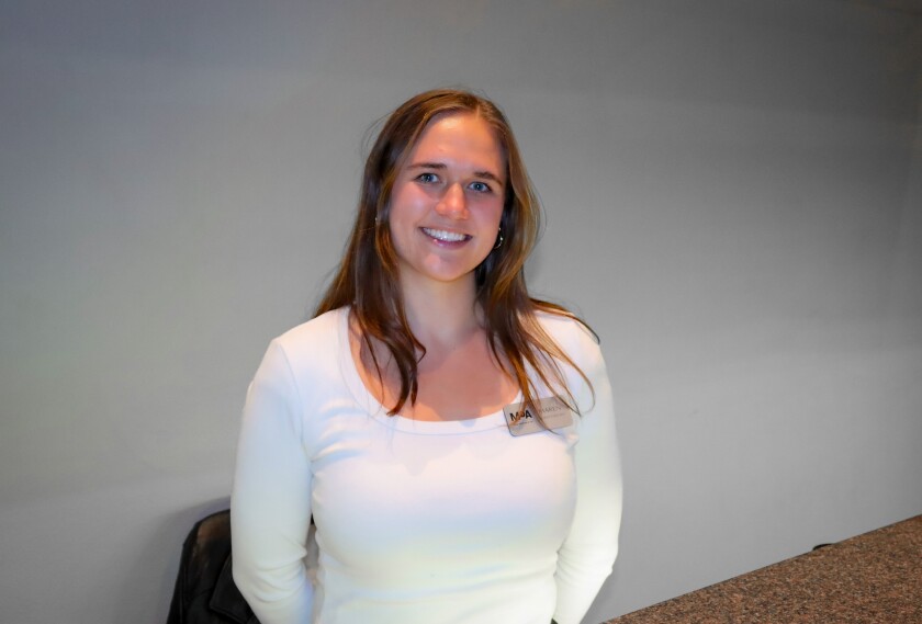 A photo of a student educator at the Front Desk of the Museum