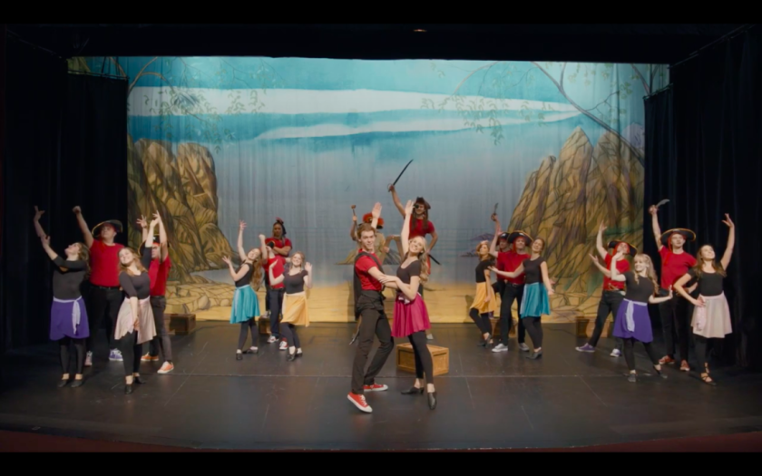 An image of actors on stage dancing
