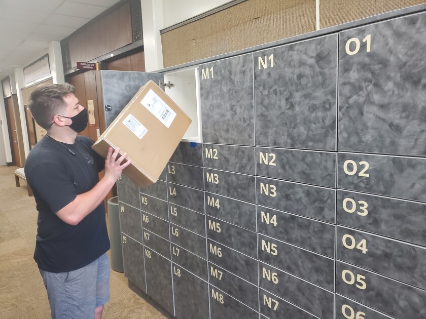 Worker putting a package into the trade winds lockers