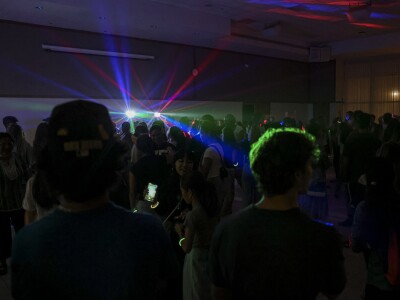 A room of students at a dance with party lights
