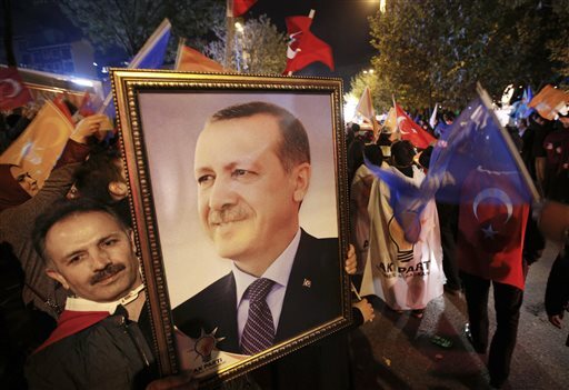 A supporter of the Justice and Development Party, (AKP), holds a portrait of Turkey