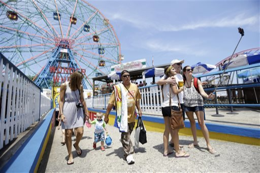 A group of people enjoying the sun and taking a selfie in front of a Ferris wheel