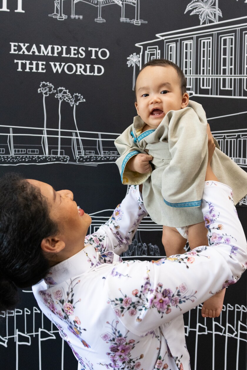 Panasuto plays with her son by lifting him in the air.