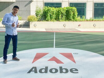 An image of Jeremy Ni standing in front of an Adobe sign