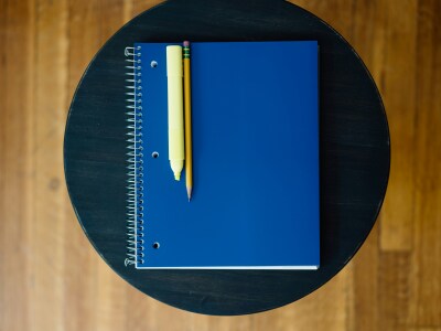 A blue book with a sharpie and pencil on it