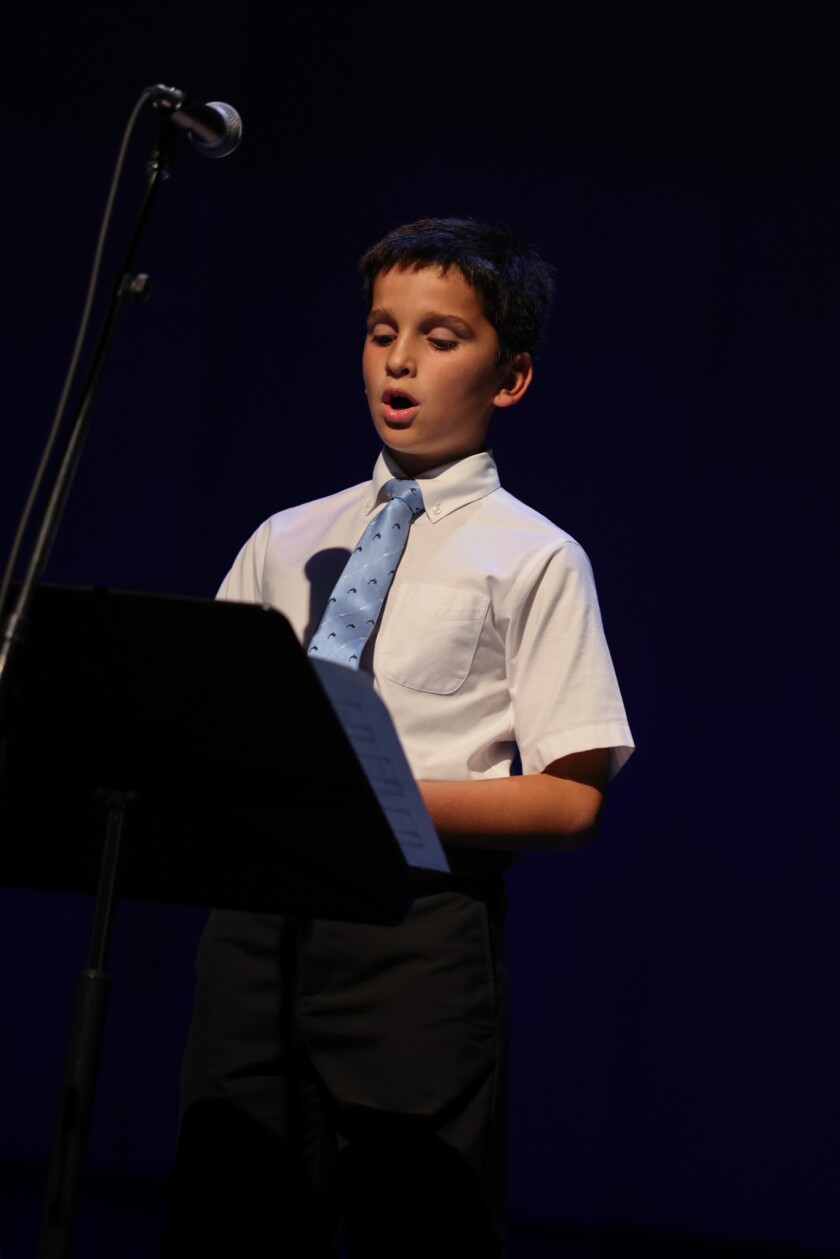 A boy singing behind a microphone.