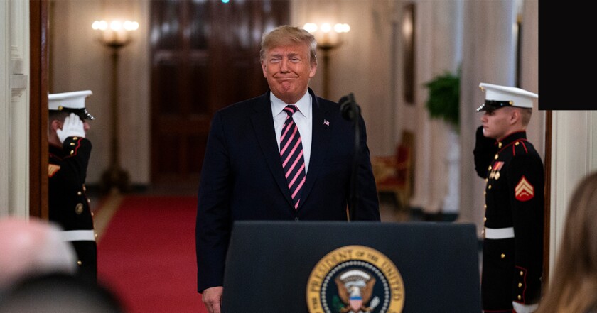 President Donald Trump walks up to his presidential podium in the White House with two marines saluting him in the background