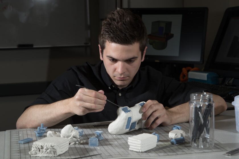 Student Andy Bryce works molds a game controller out of clay
